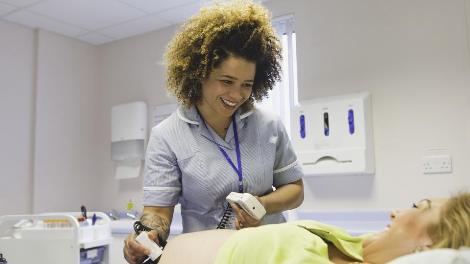 A midwife scanning a patient