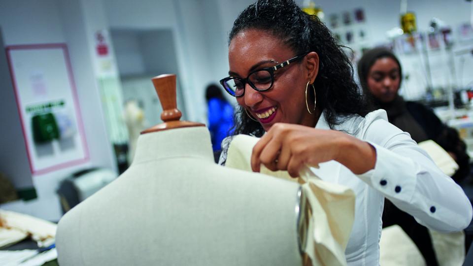 A fashion designer working with a mannequin