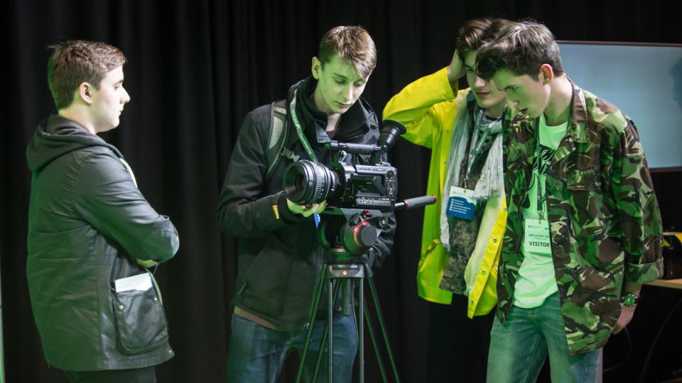 Budding filmmakers surrounding a camera