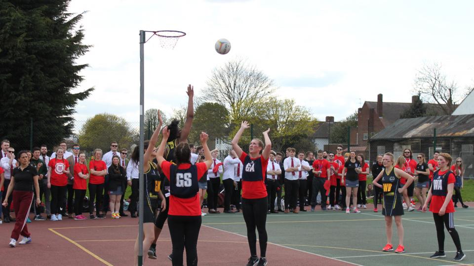 Students playing netball with onlookers 