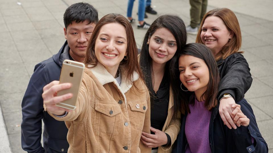 Five students taking a selfie and smiling