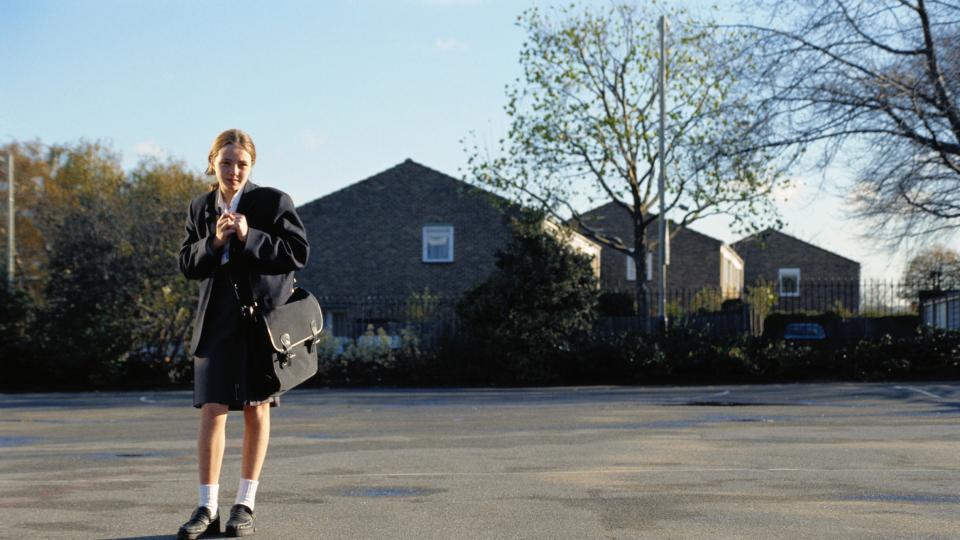 Girl standing in empty lot in a school uniform