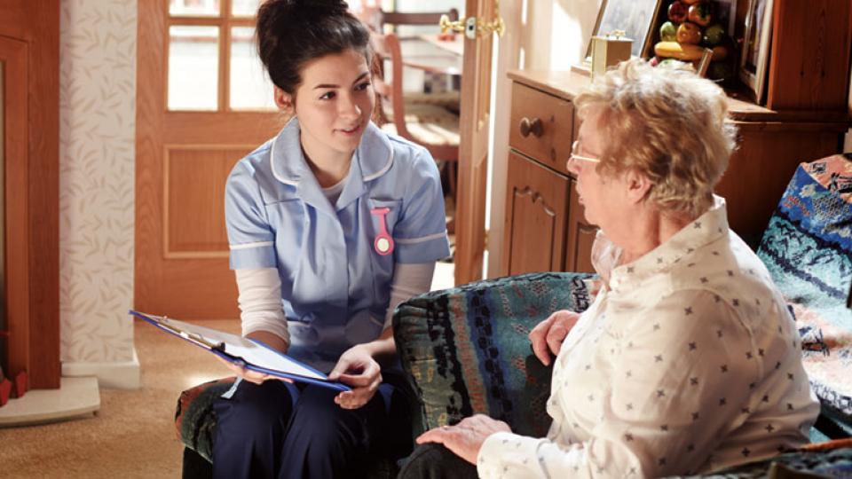 A nurse talks to an elderly patient