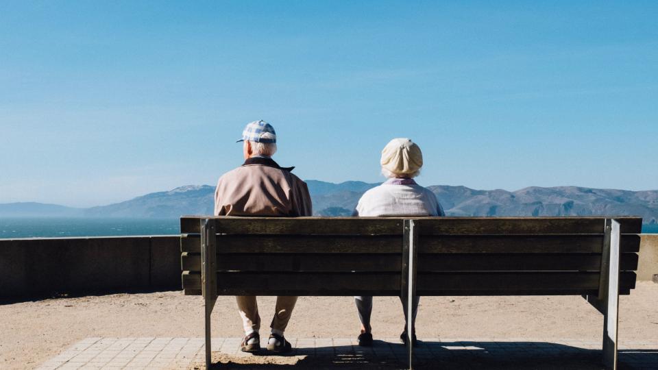 An old couple on a bench by the sea