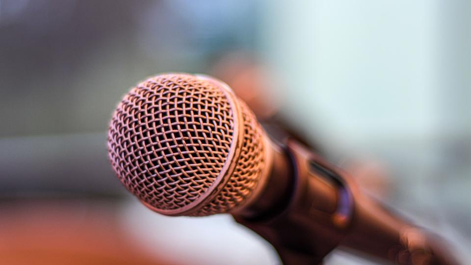 Close up of a microphone in front of a blurred background