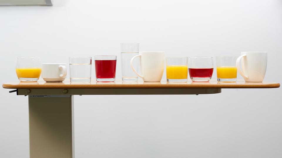 A photo of a selection of different drinks in a row on a bedside table