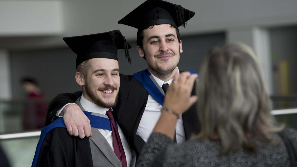 Two male graduates posing for a photo.