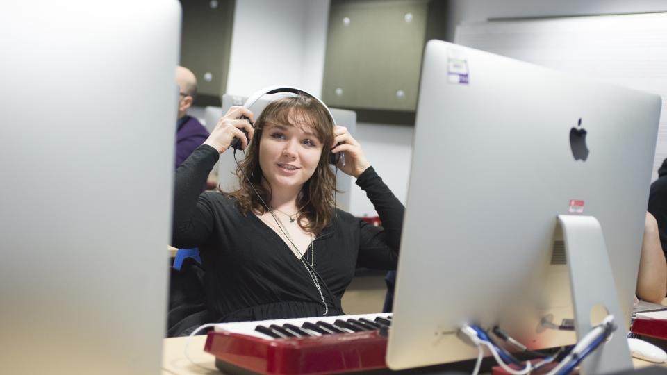A student composes music on a Mac computer