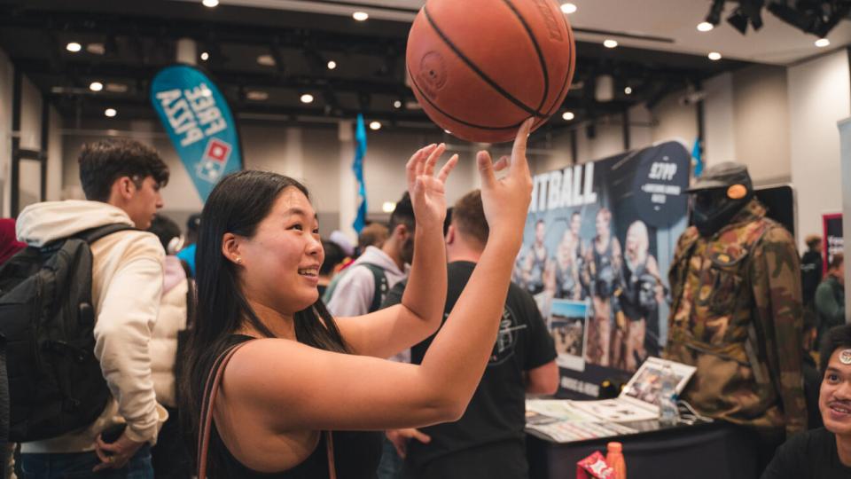 A student holding a basketball at one of UWL's Freshers Fairs