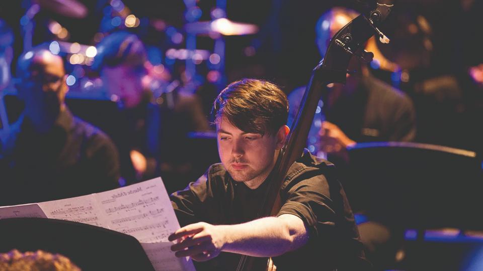 A young man fixing sheet music during a musical performance