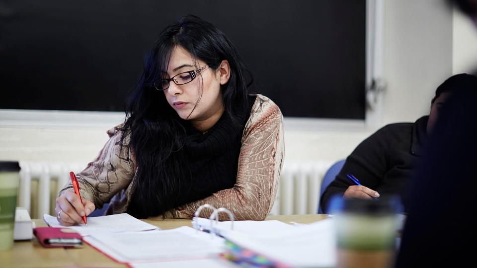 A female student with glasses writing notes