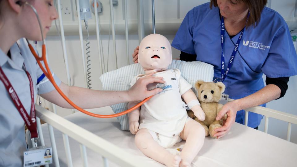 A female student monitoring the heartbeat of a dummy baby