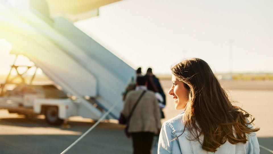 A passenger about to board a plane on a sunny day