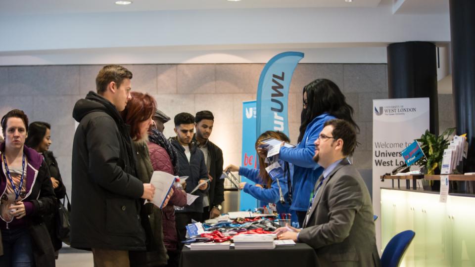 Students at an open day talking to staff.