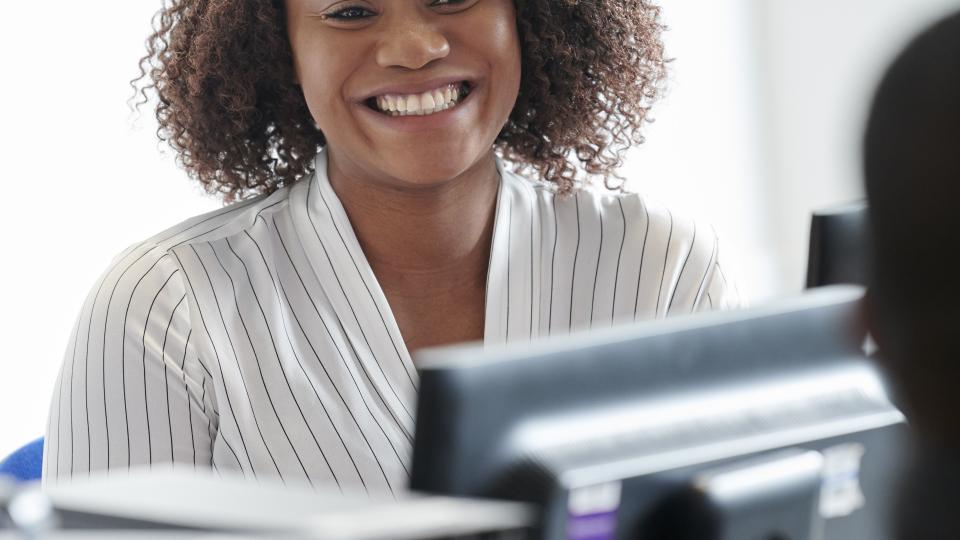 Woman behind a computer smiling