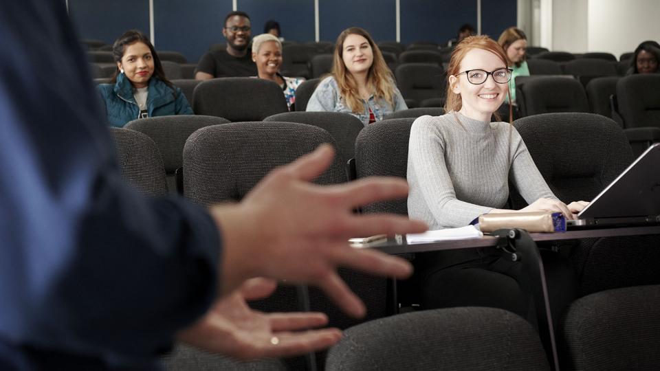 A group of students smiling during a lecture