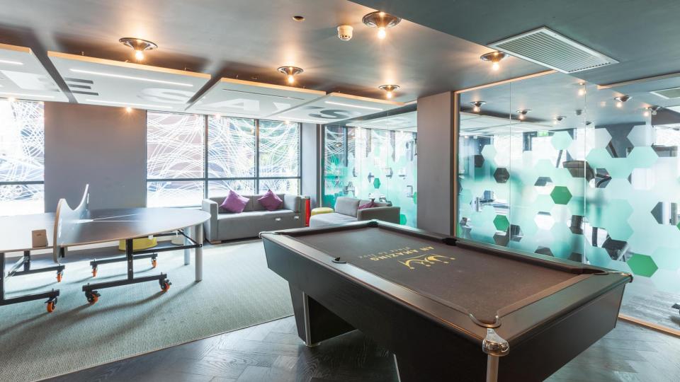 Modern-looking communal games room with pool table and seating