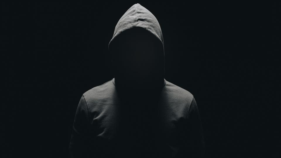 Faceless person wearing a dark hoodie