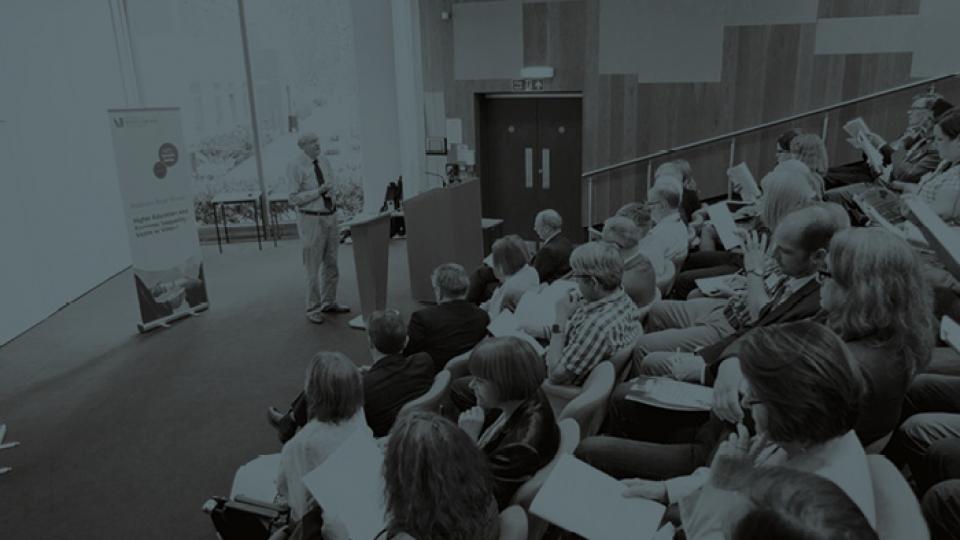 An academic conference, during which a speaker is presenting to a large group