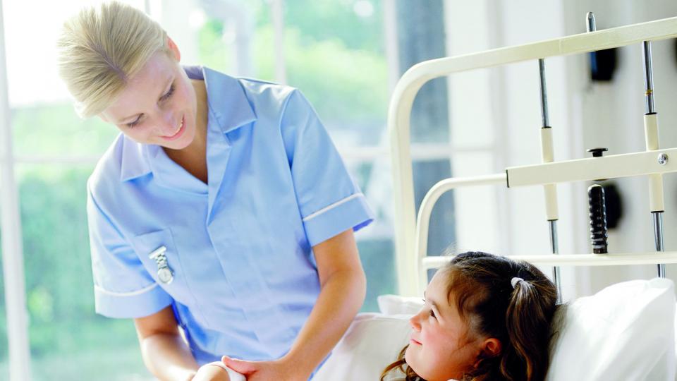 A nurse cares for a child on a hospital ward