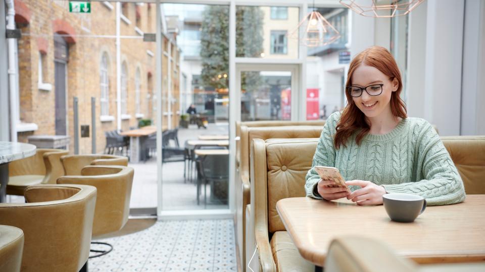 A person using a phone in a cafe