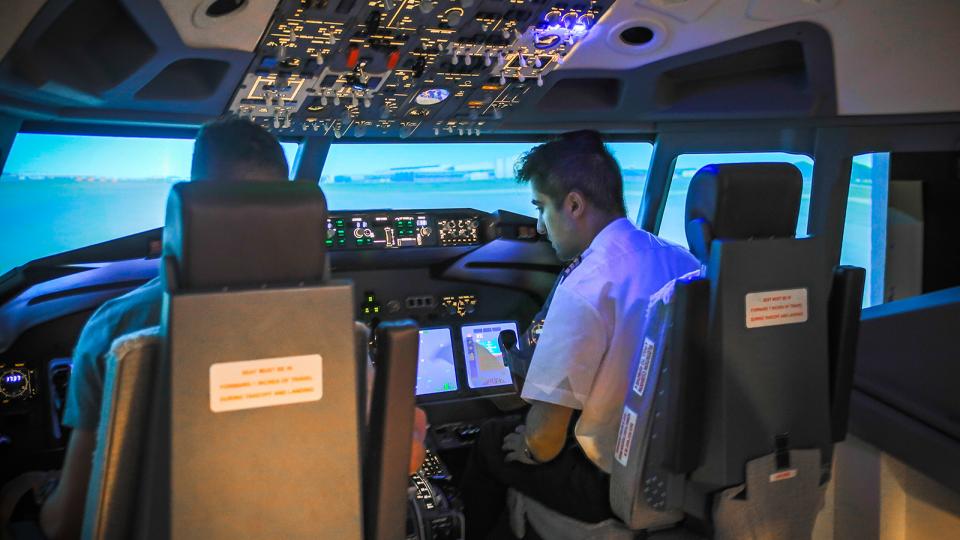 An instructor with an aspiring pilot in a simulator