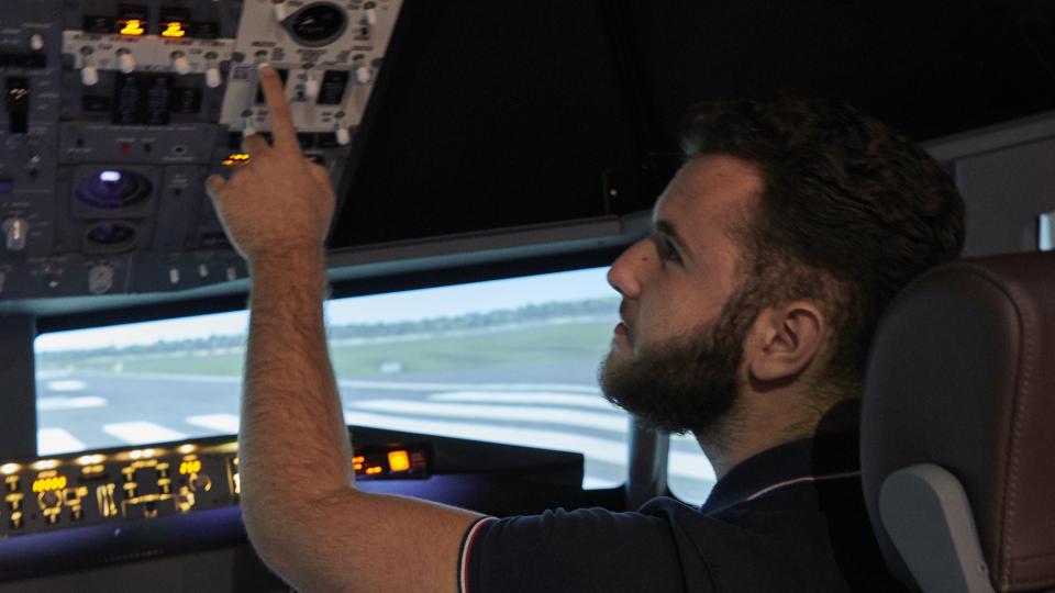 An aspiring pilot performing a check in a simulator cockpit