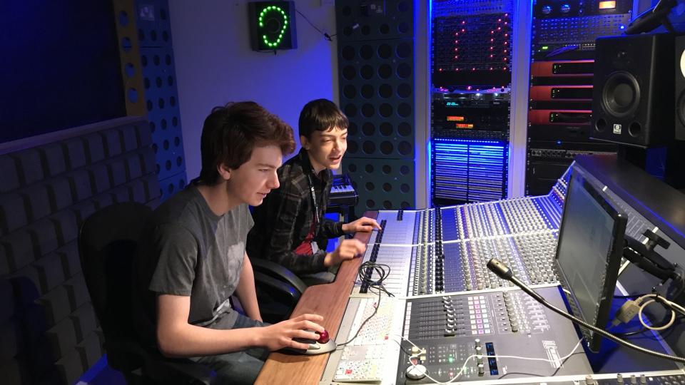 Two budding studio engineers learning how to use the equipment at a recording studio