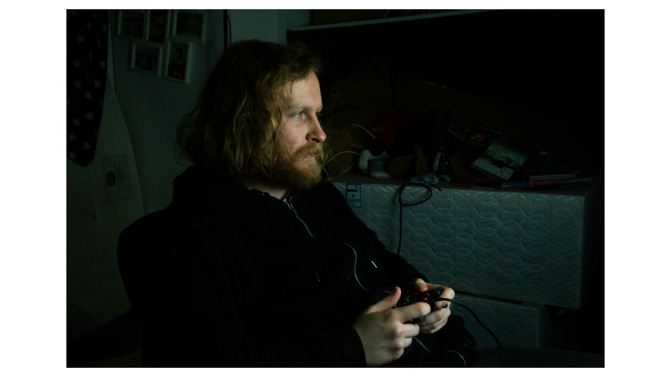 A man playing a video game in a dark room.