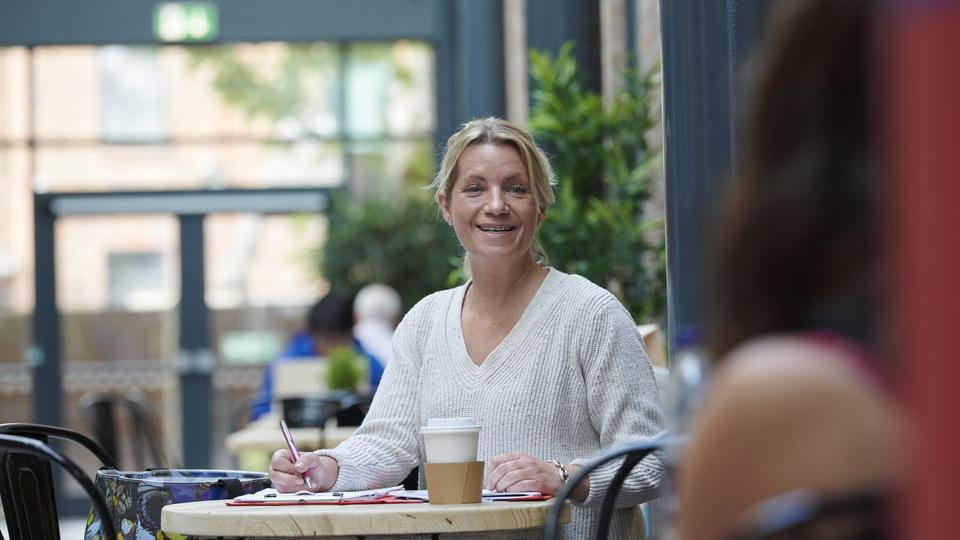 mature female student at the cafeteria having coffee