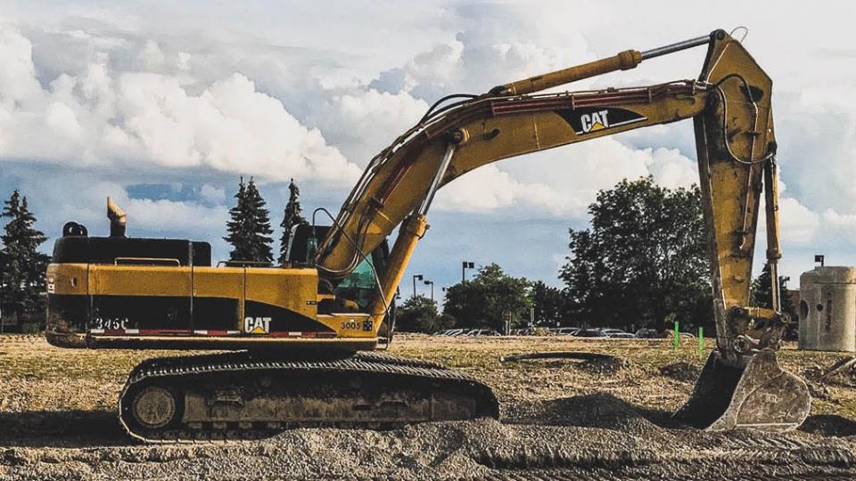A Caterpillar excavator on a road-side building site