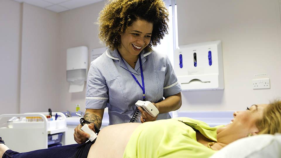 A midwife uses an ultrasound scanner 