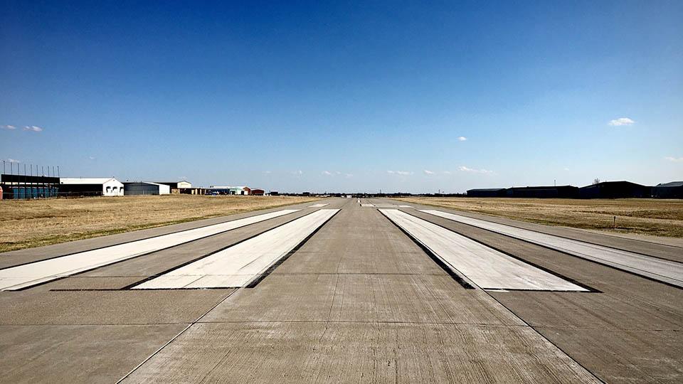 A grey runway pictured on a sunny day