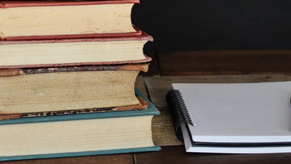 Academic books and notepad with pen 