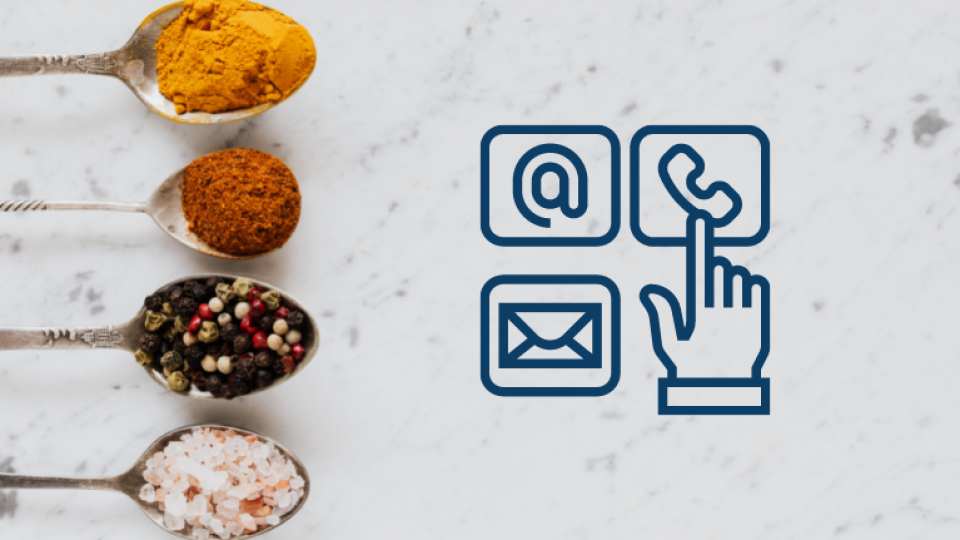 4 spoons with different herbs and spices in each to the left of the screen. The background is a white marble. There are 3 contact us logos to the right; a web symbol, telephone and email.