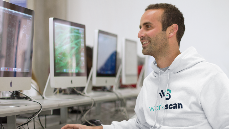 A Workscan advocate looking at a computer monitor, wearing a Workscan hoodie.