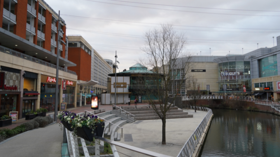 This image depicts the river thames running through the main restaurant area which is part of the Oracle in Reading Town. In the image there is a Pizza hut, a Nandos, Lemoni and House of Fraser.