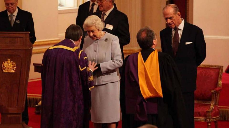 Peter John receiving the CBE from The Queen
