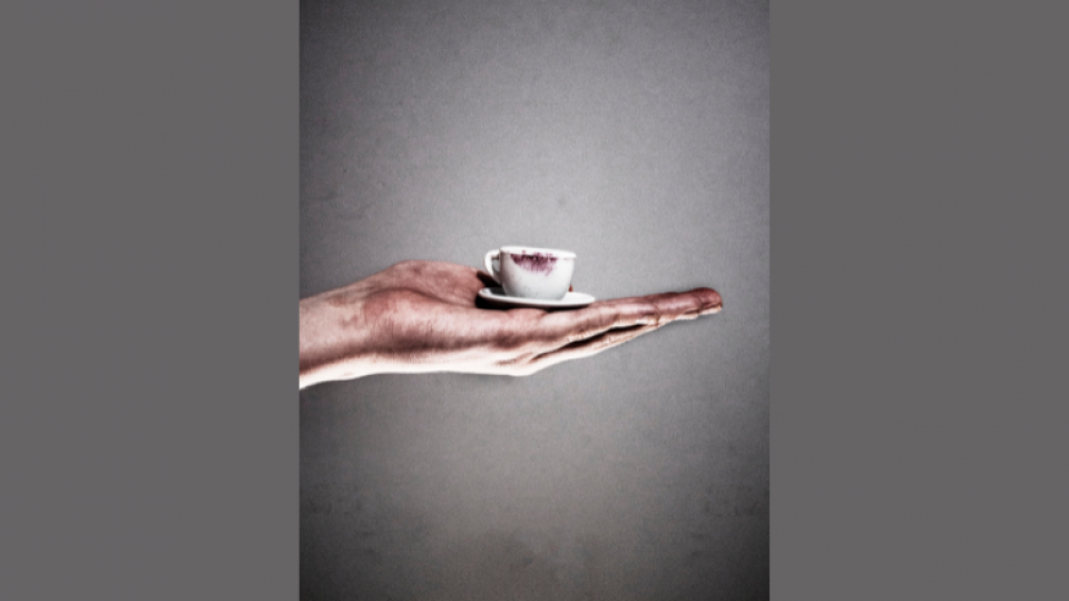 A student photo of a small tea cup in the palm of someone's hand.