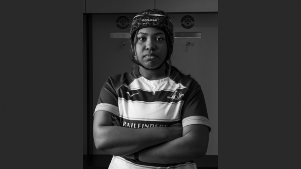 Student photography of a student in rugby clothes and gear with crossed arms.