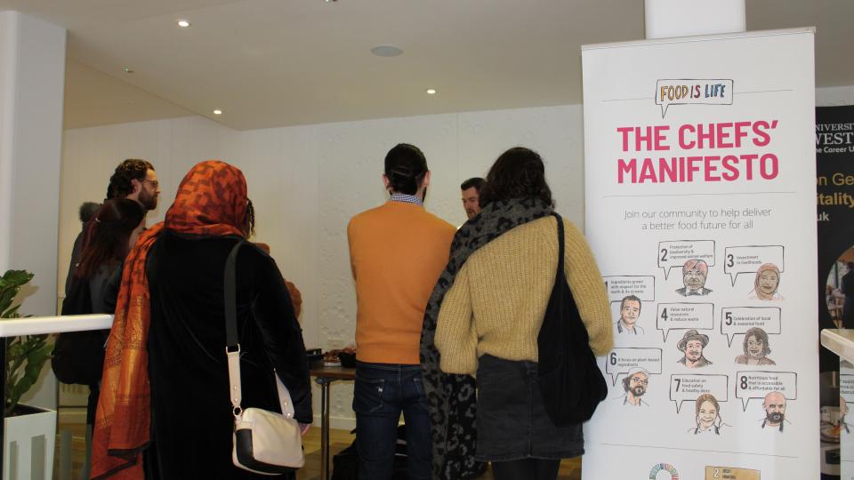 People attending the Future Plates and Future Chefs event walking past a banner stating 'The Chefs' Manifesto'