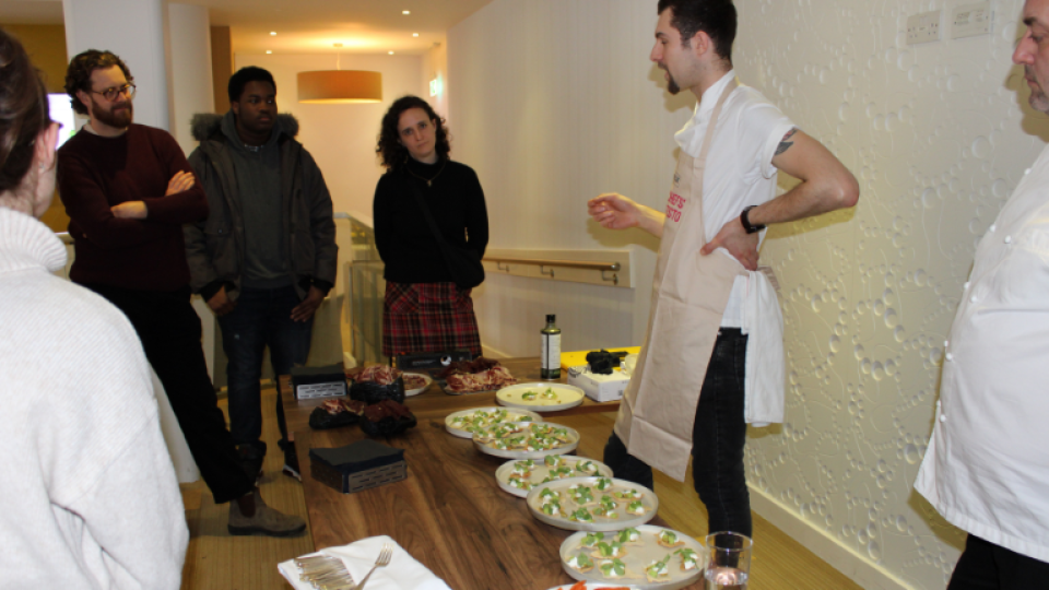 A chef presenting prepared food to people at the Future Plates and Future Chefs event