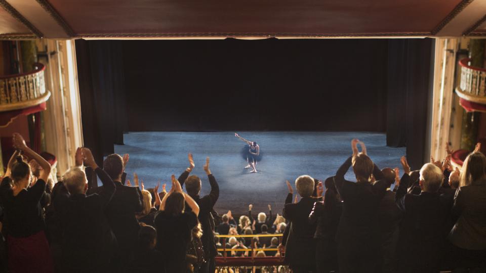 Crowd applauds an actor on stage