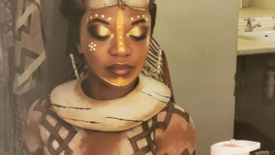 Brianna Ogunbawo dressed as a lion for a performance of The Lion King