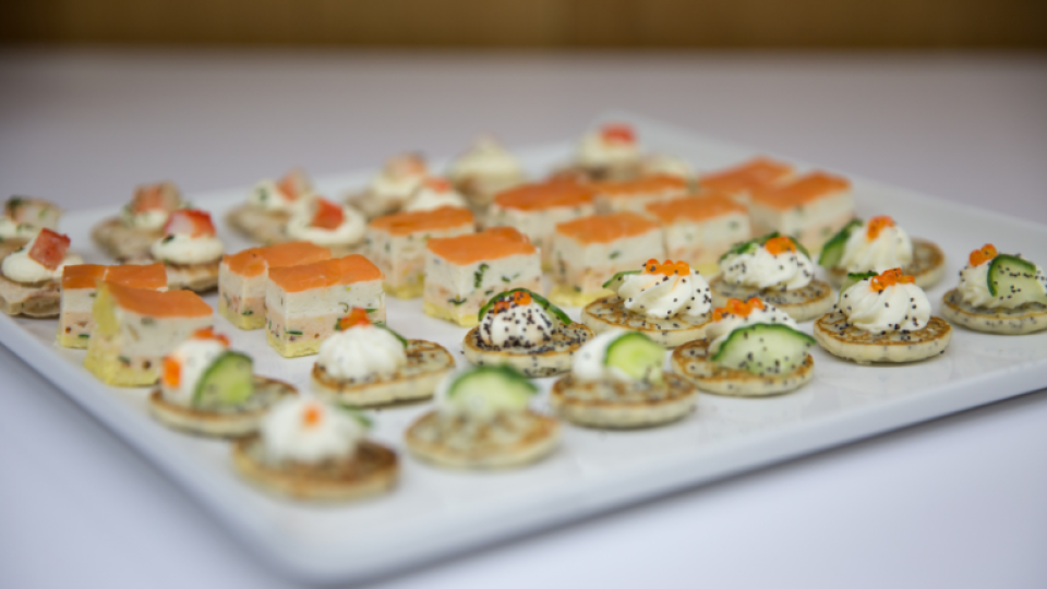 A selection of savoury canapés served on a square white plate.