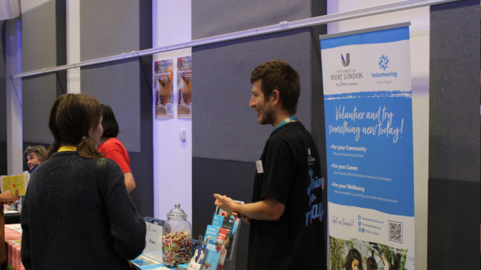 A staff member from the V Team speaking to students at the volunteering fair.
