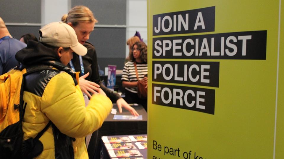 A rep from the police talking with students at the Law Careers Fair