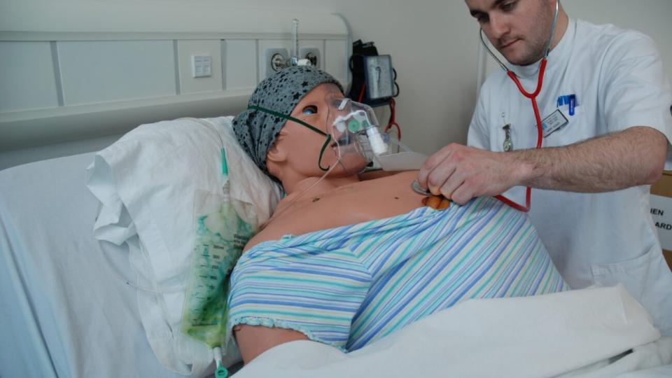 A nurse using a stethoscope on a dummy in the UWL simulation centre
