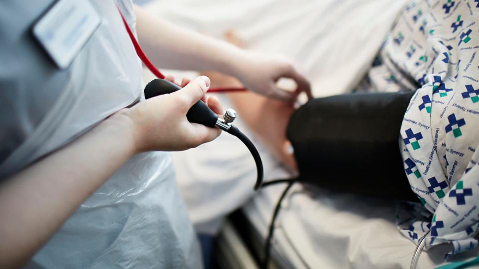 A nurse taking someone's blood pressure