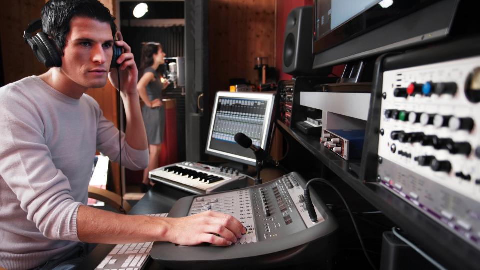 A man listening on headphones in a sound studio